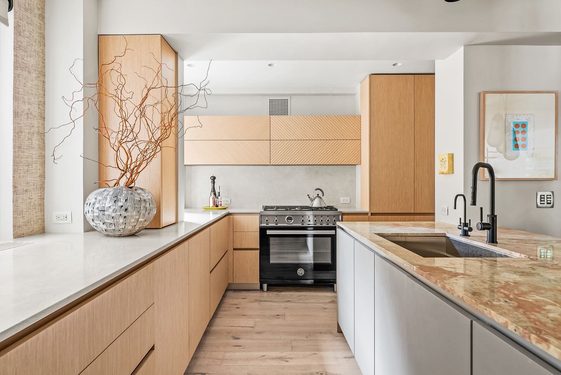 A kitchen with wooden cabinets , granite counter tops , a stove and a sink.