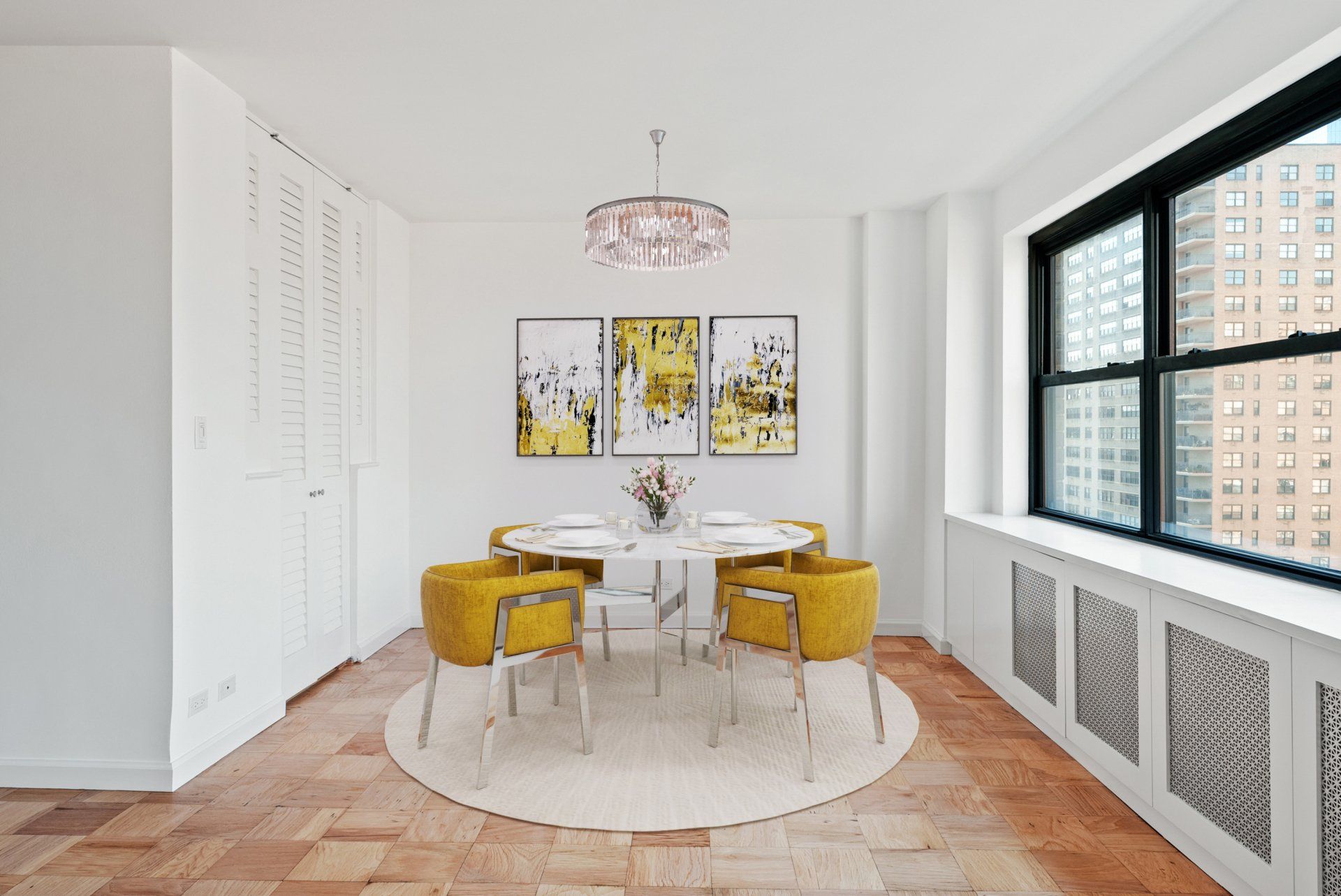 A dining room with a table and chairs and a large window.