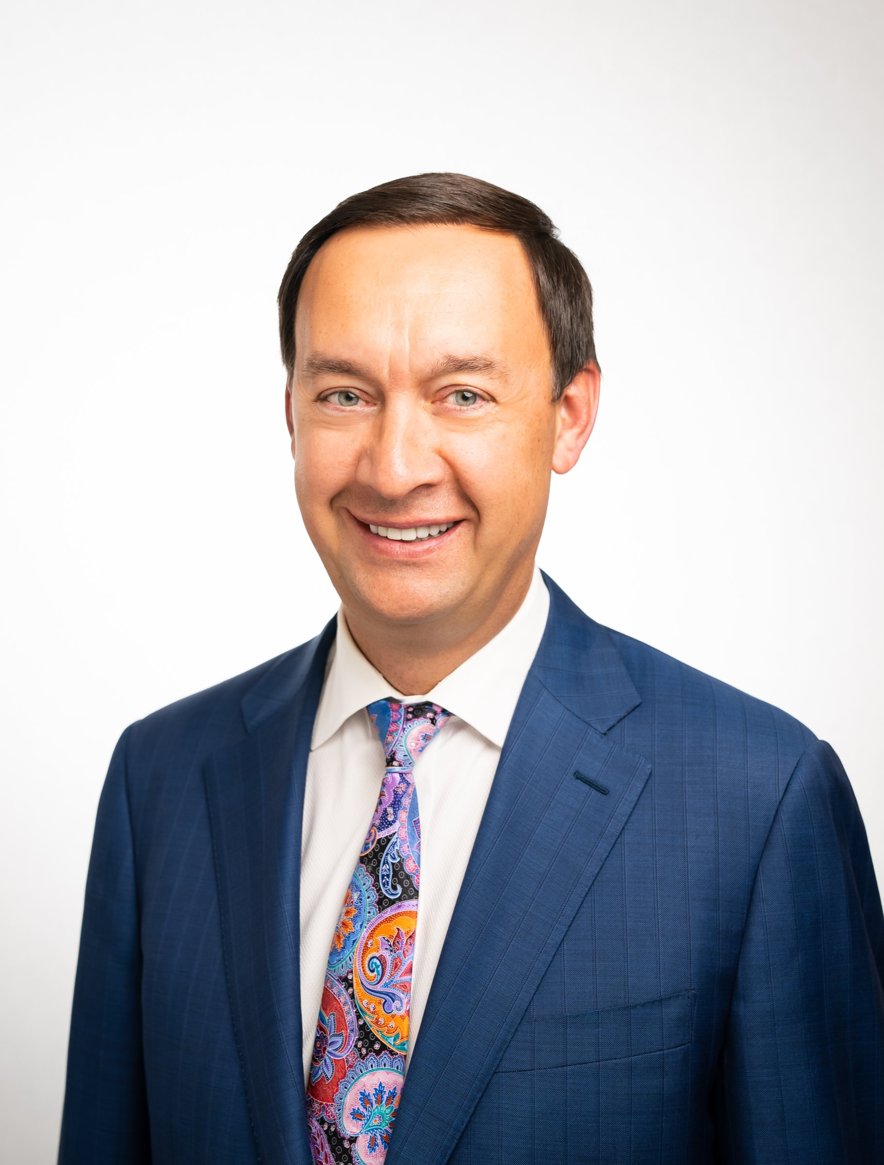 A man in a suit and tie is smiling for the camera.