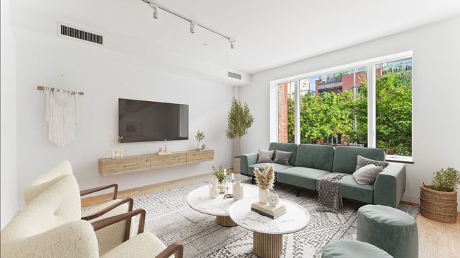 A living room with a couch , chairs , coffee table and television.