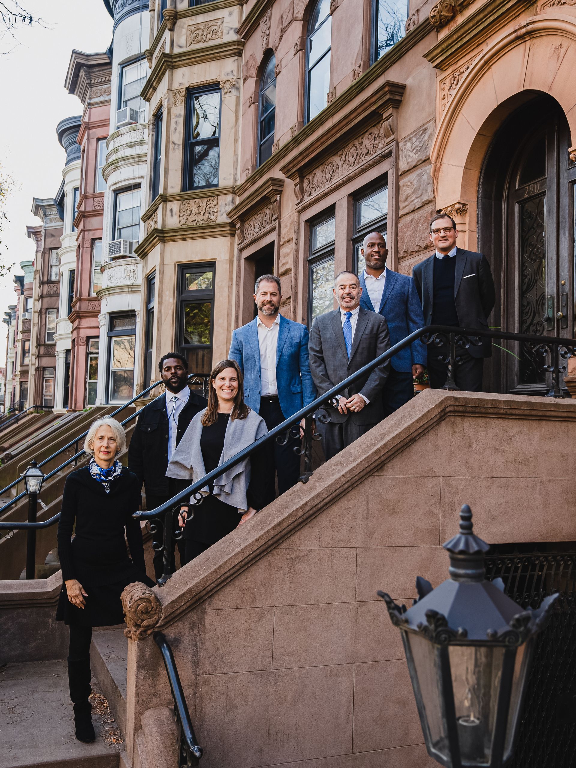 A group of people are standing on the steps of a building.