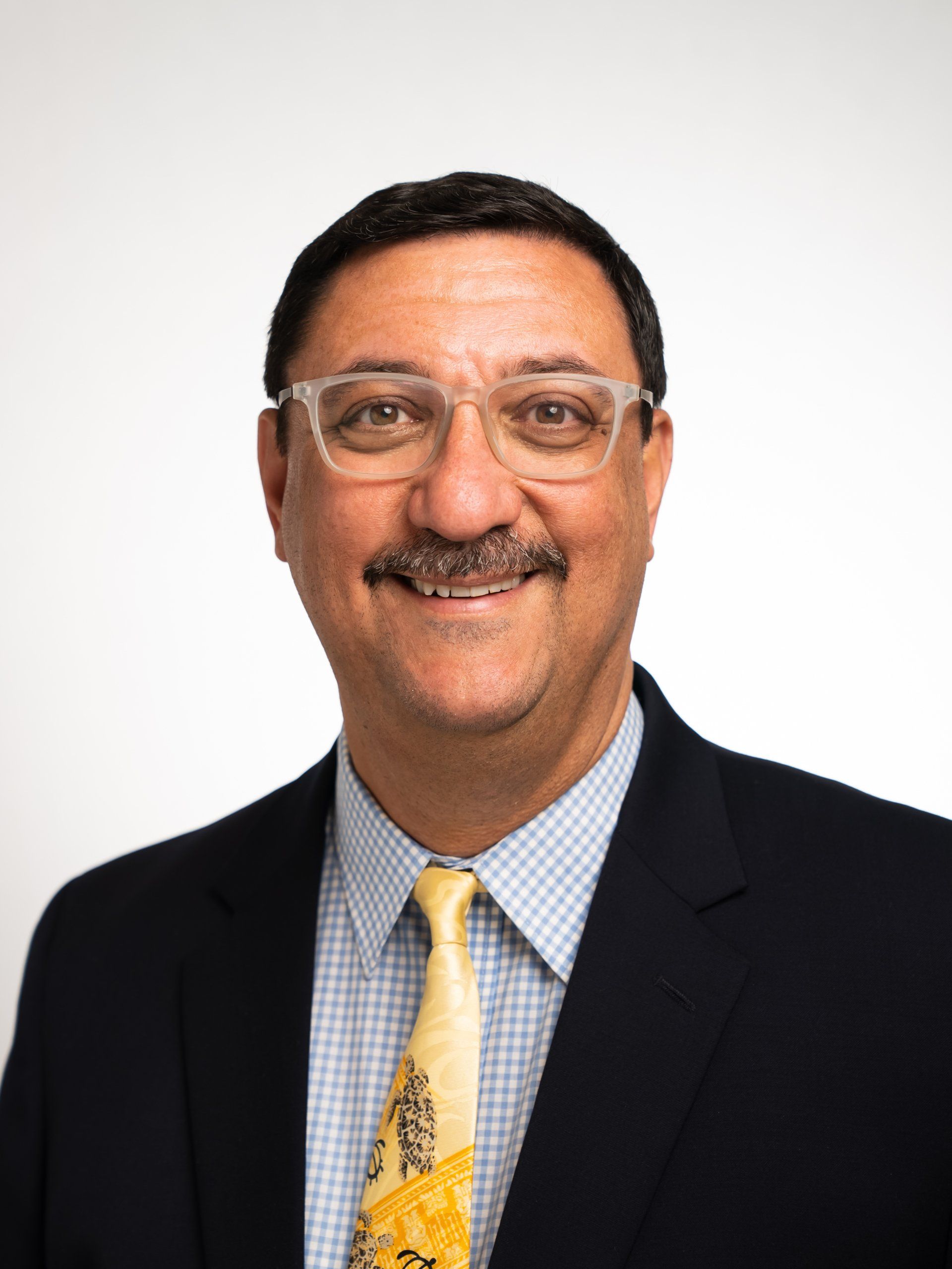 A man in a suit and tie is smiling for the camera.