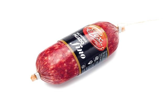 Salami Picado Fino, un embutido pequeño, cilíndrico, con una etiqueta negra, atado con un cordón sobre un fondo blanco.