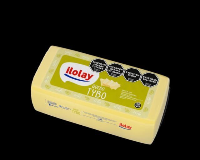 Bloque de queso Iloay Queso Tybo, amarillo con etiqueta verde y texto negro sobre fondo negro.