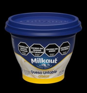 Envase azul y amarillo de queso untable Milkaut, con etiquetas de advertencia.