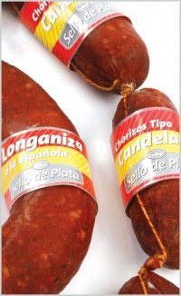 Primer plano de tres embutidos españoles (longaniza y chorizo) con etiquetas amarillas sobre fondo blanco.