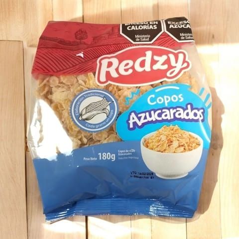 Bolsa de copos de maíz azucarados Redzy sobre una superficie de madera.