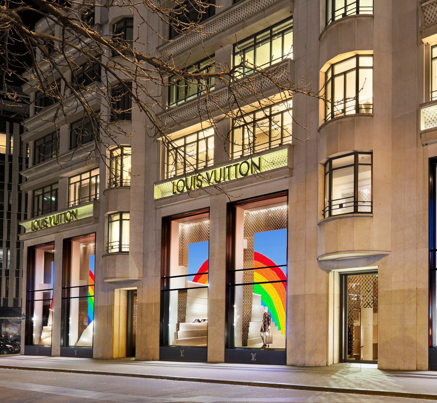 A louis vuitton store is lit up at night
