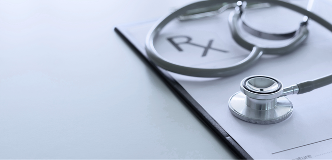 Stethoscope and eyeglasses on a clipboard with a medical prescription, in a clean clinical setting