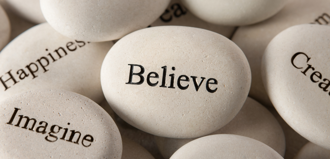 White pebbles with words like “Believe,” “Imagine,” and “Happiness” printed on them