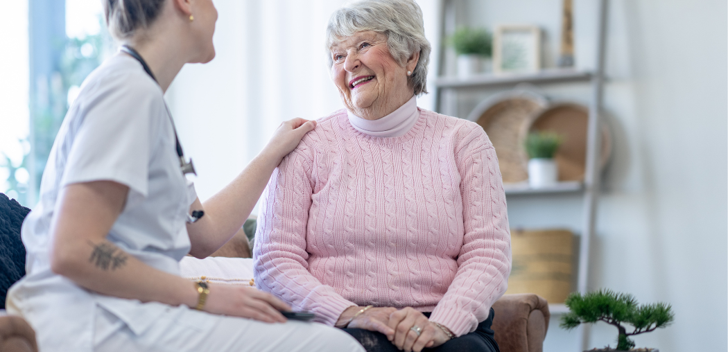Caregiver speaking with a smiling patient in a bright clinic waiting area