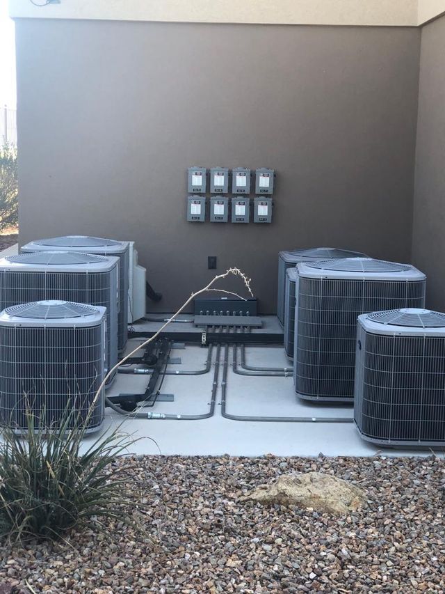 Outdoor HVAC units installed near a building with electrical meters.