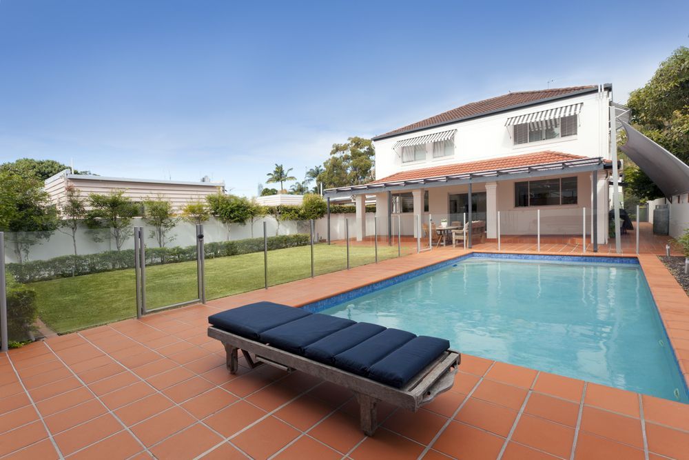 There is a Large Swimming Pool in the Backyard of a House — Whitsunday Architectural Windows & Doors in Proserpine, QLD