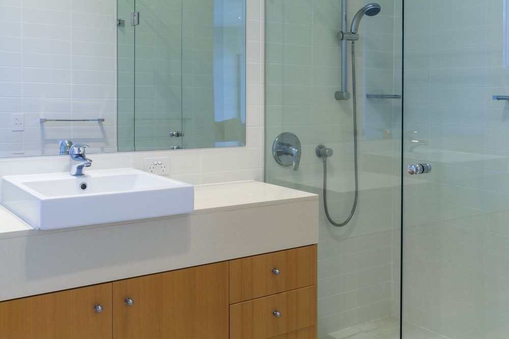 A Bathroom With a Sink, Shower and Mirror — Whitsunday Architectural Windows & Doors in Proserpine, QLD