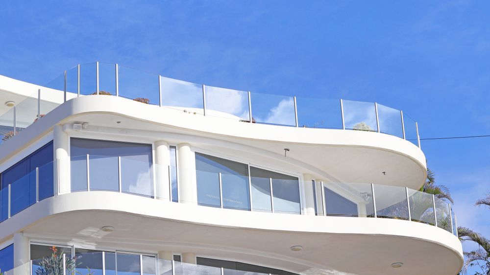 A Large White House With a Balcony and a Blue Sky in the Background — Whitsunday Architectural Windows & Doors in Airlie Beach, QLD