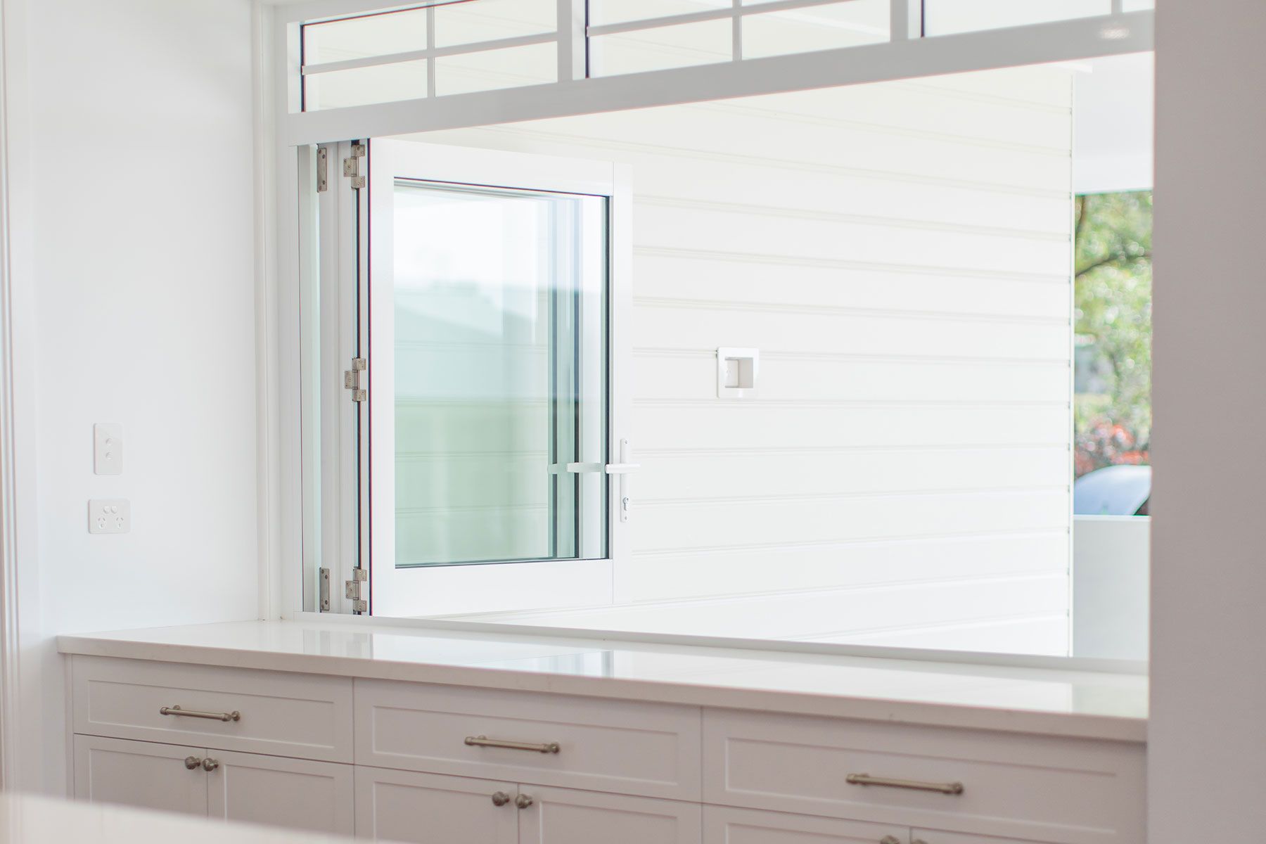 A Dog is Sitting on a Couch in a Living Room Next to a Table — Whitsunday Architectural Windows & Doors in Proserpine, QLD