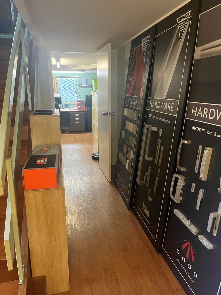 A Hallway With a Staircase and a Display of Hardware on the Wall — Whitsunday Architectural Windows & Doors in Proserpine, QLD