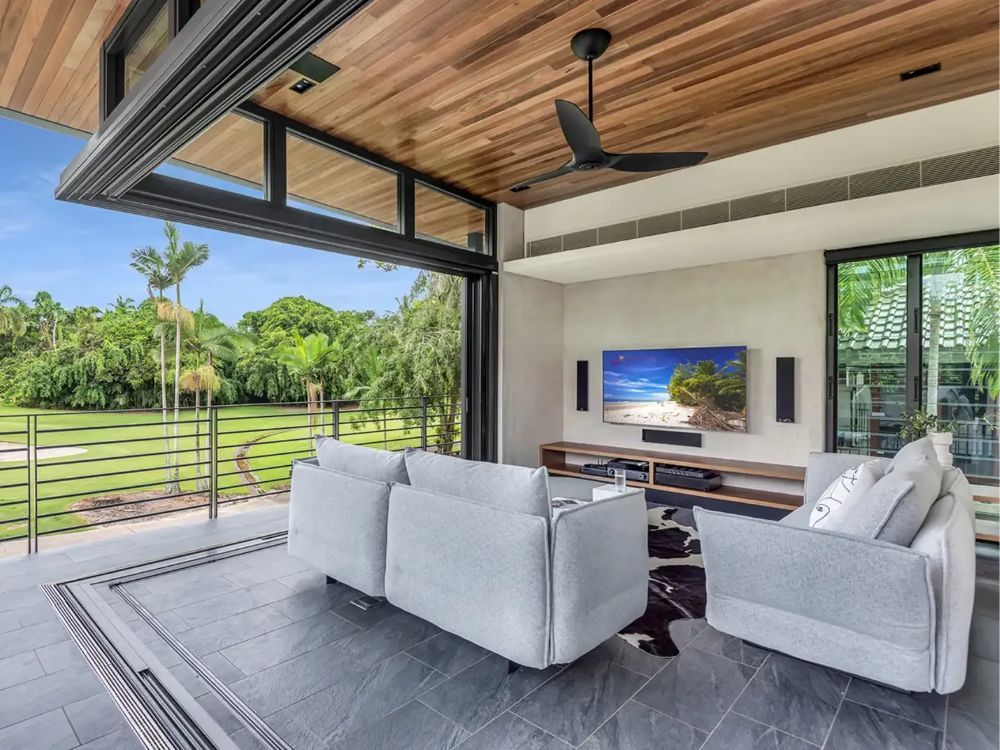 A Living Room With a Ceiling Fan and a Flat Screen TV — Whitsunday Architectural Windows & Doors in Proserpine, QLD