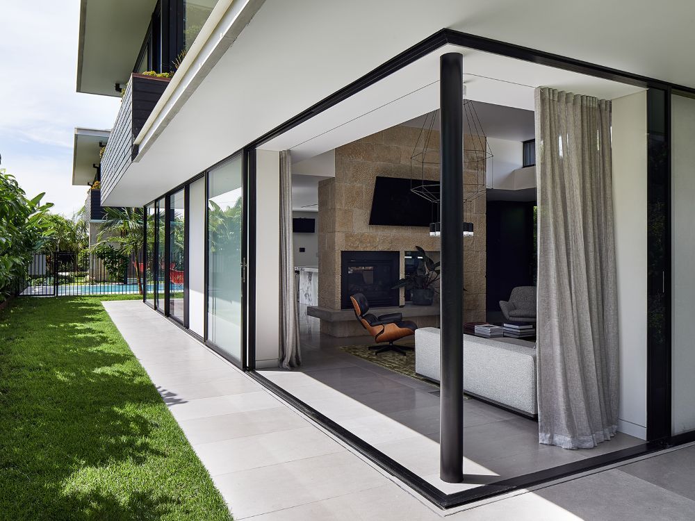 A Modern House With a Large Sliding Glass Door Leading to a Living Room — Whitsunday Architectural Windows & Doors in Proserpine, QLD