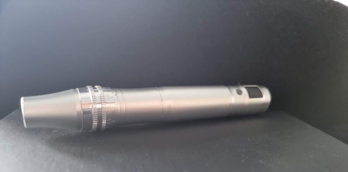 Een zilveren pen zit op een zwart oppervlak.