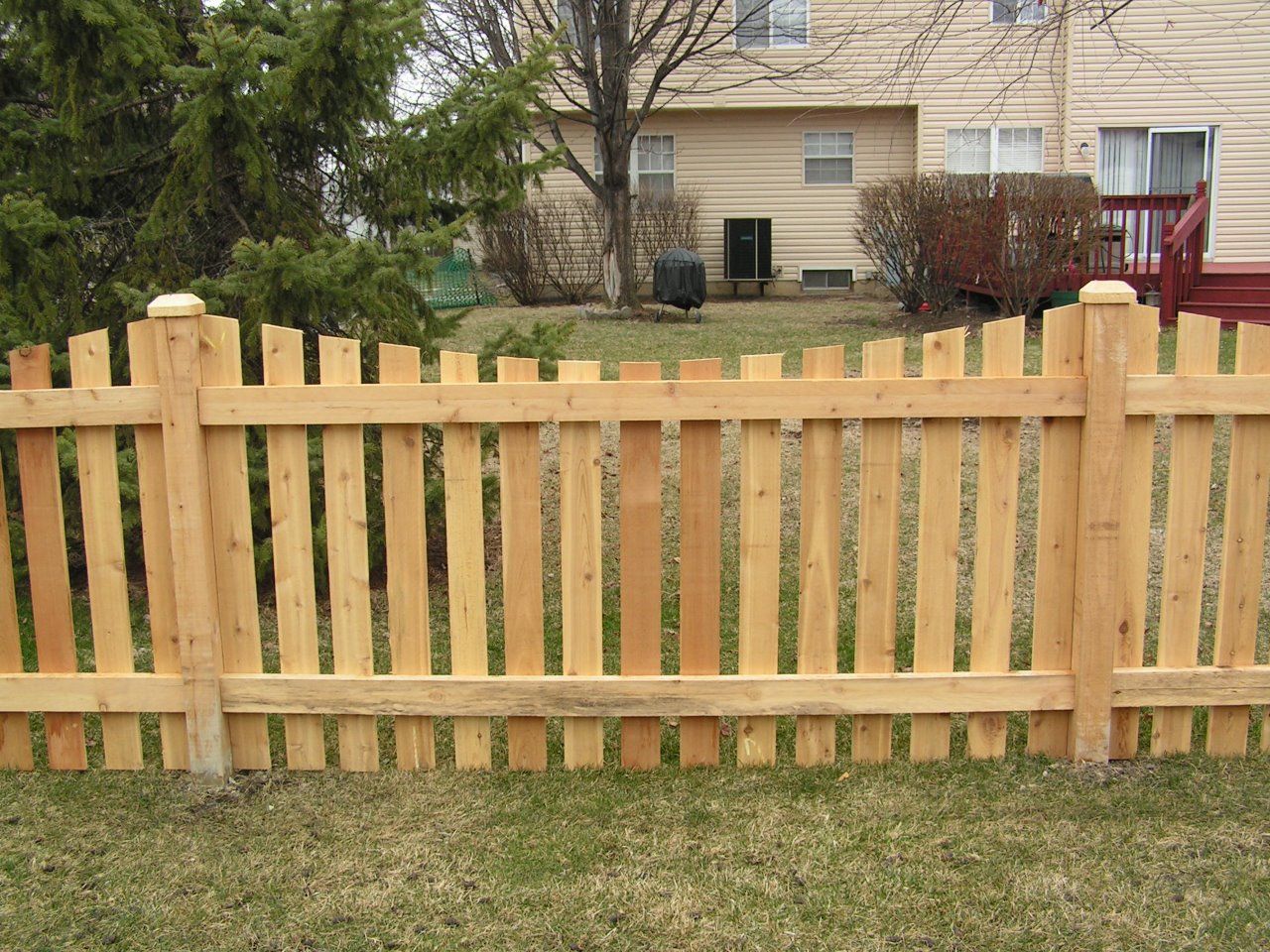 A wooden picket fence in front of a house