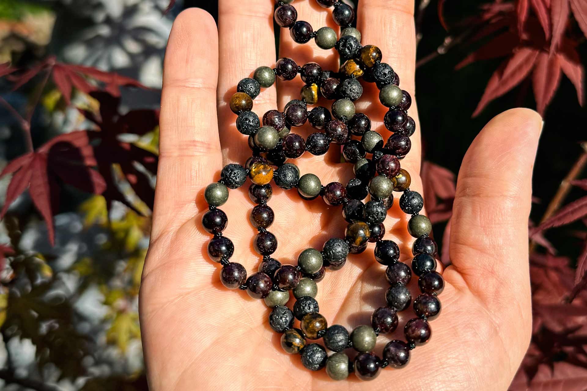 Une personne tient un collier dans sa main.