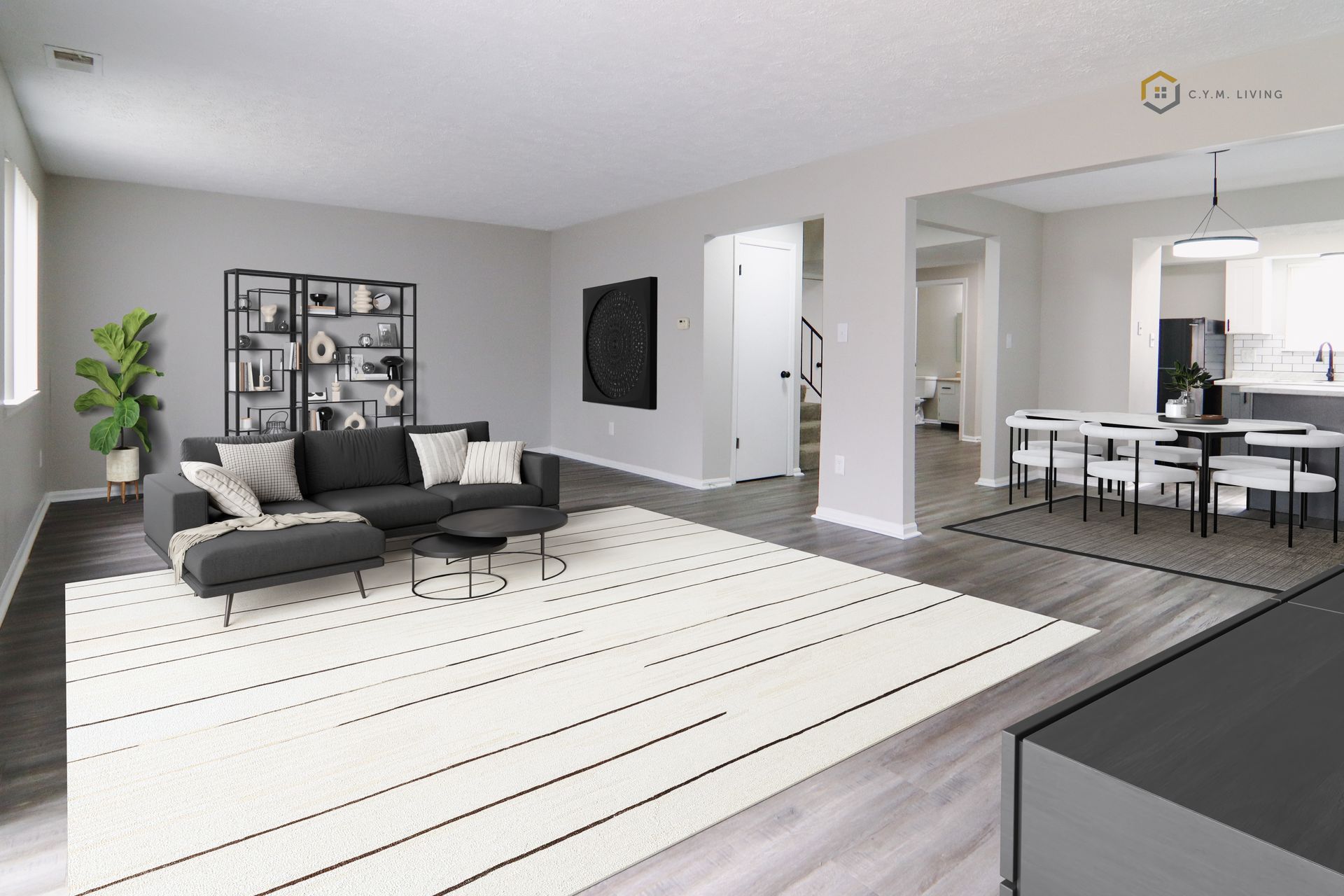 Open-concept living area with gray walls, a black couch, a white rug, and a dining area with a white table.