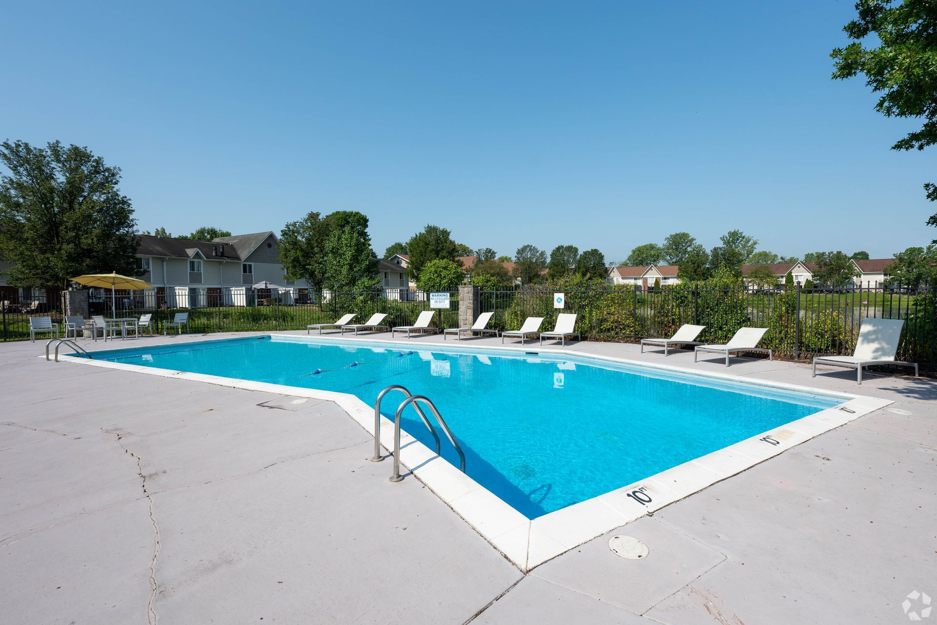 Swimming pool with lounge chairs on a sunny day.