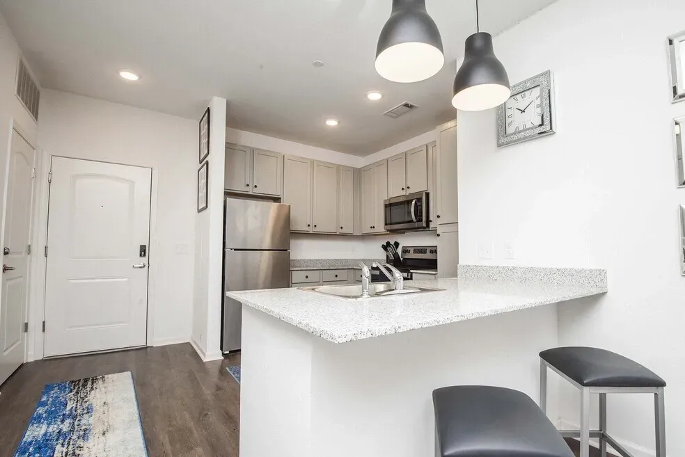 Modern kitchen with stainless steel appliances, granite countertops, and ample cabinet space.