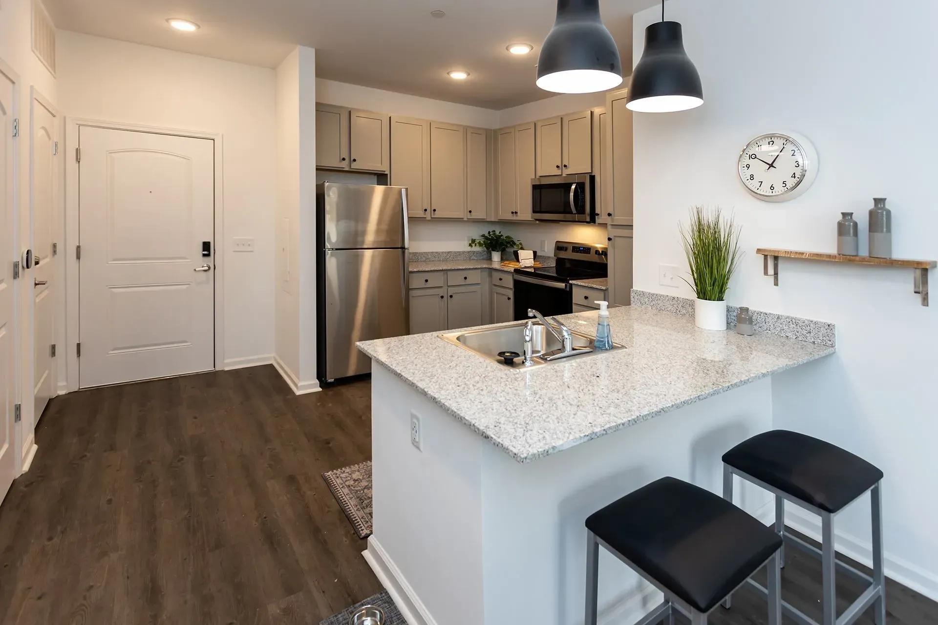 Modern kitchen with granite countertops, stainless steel appliances, and breakfast bar.