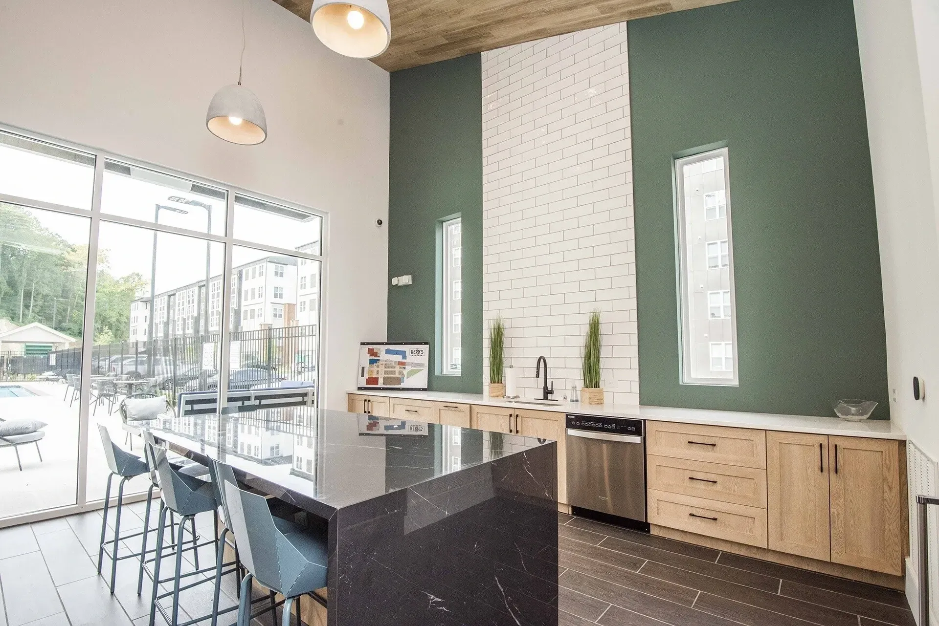 Modern community kitchen with granite island, stainless steel appliances, and ample seating.