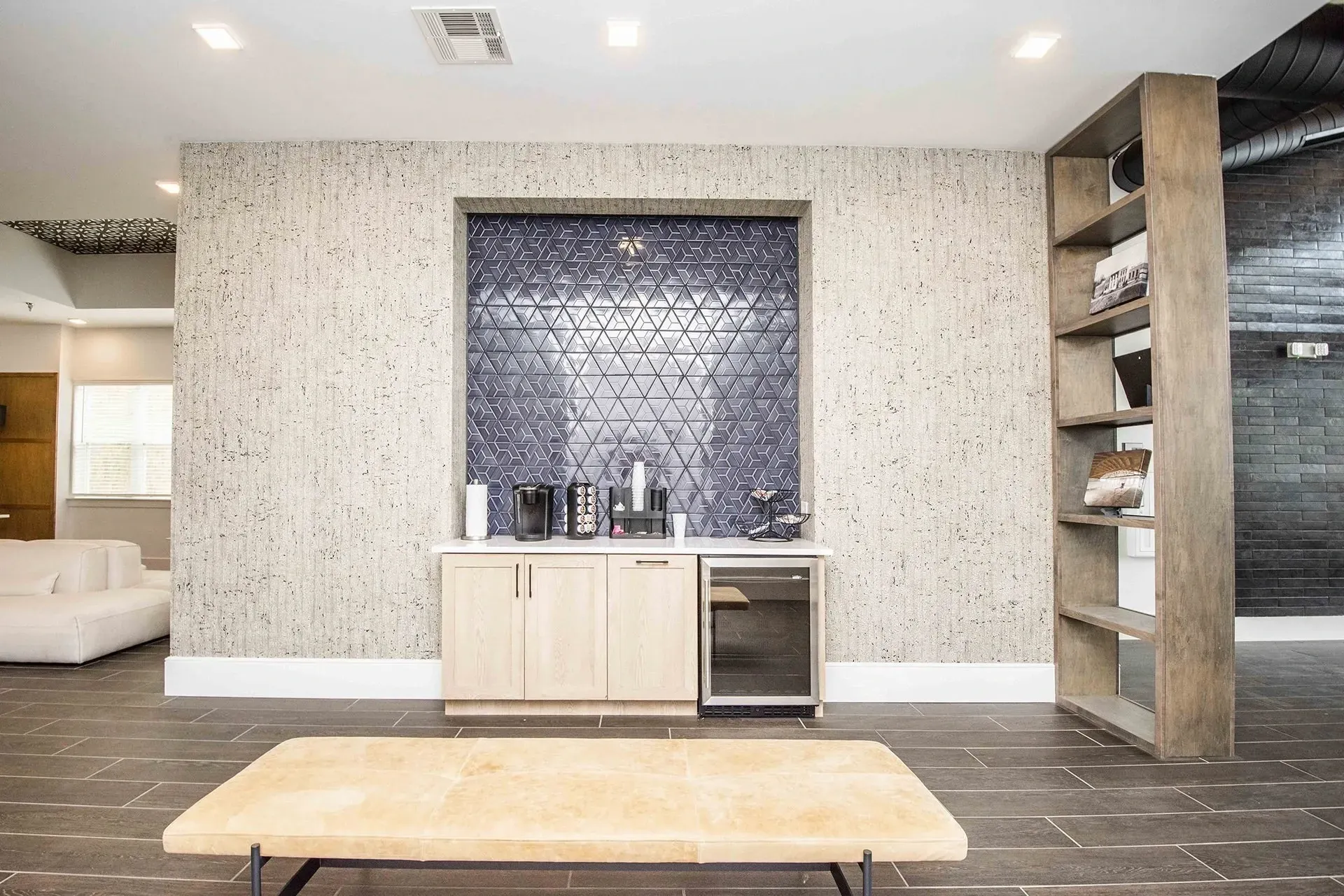 Community coffee bar with modern tile backsplash and beverage station.