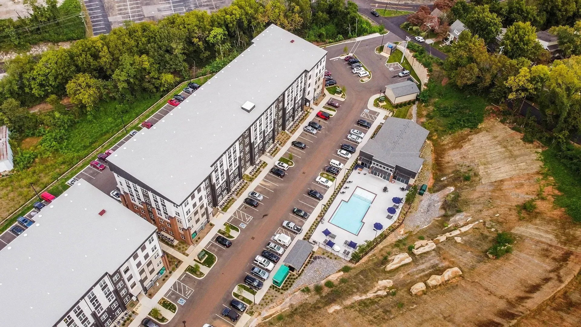 Aerial view of apartment buildings and a swimming pool.