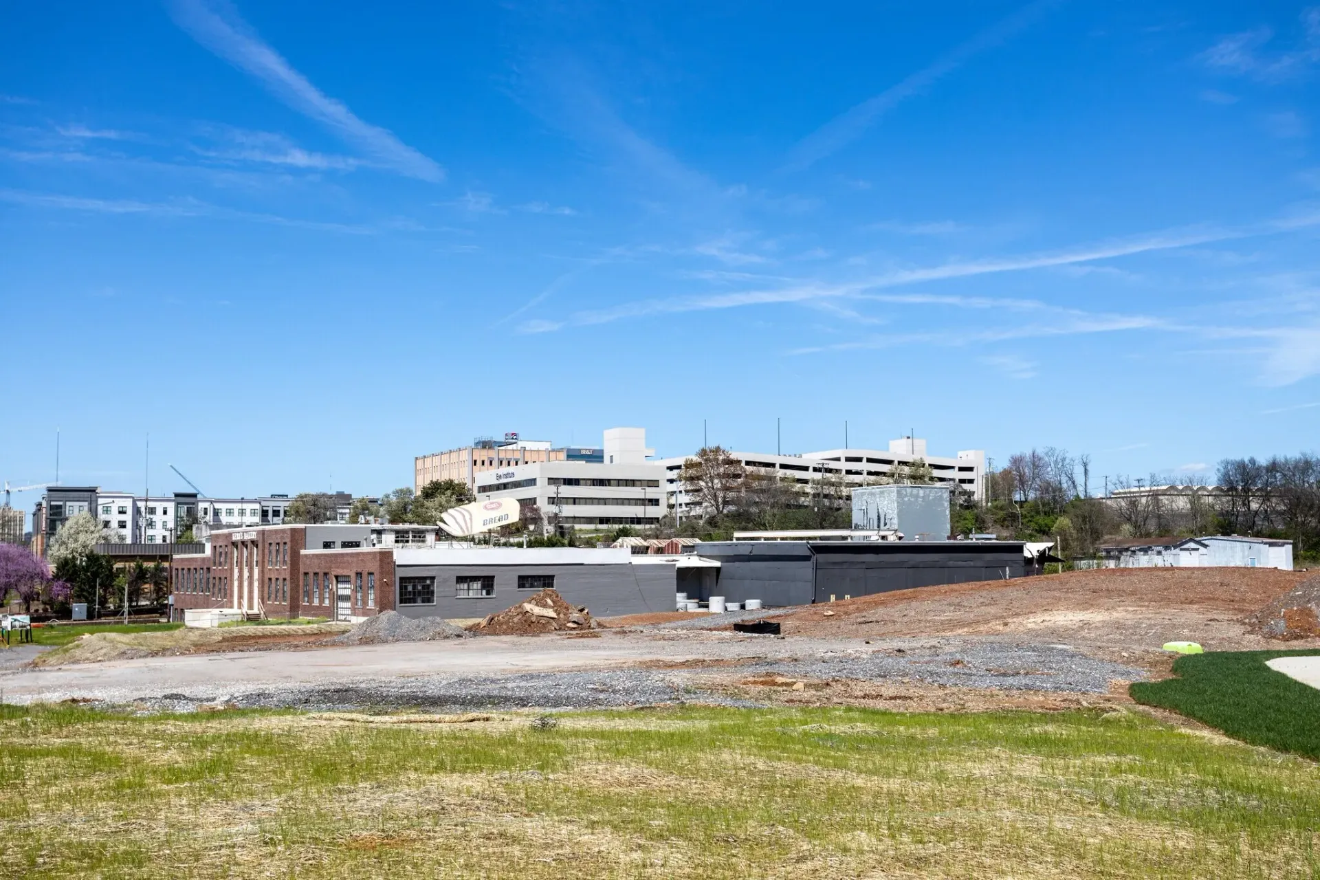 Exterior view of a modern apartment complex with brick and grey buildings under a clear blue sky.