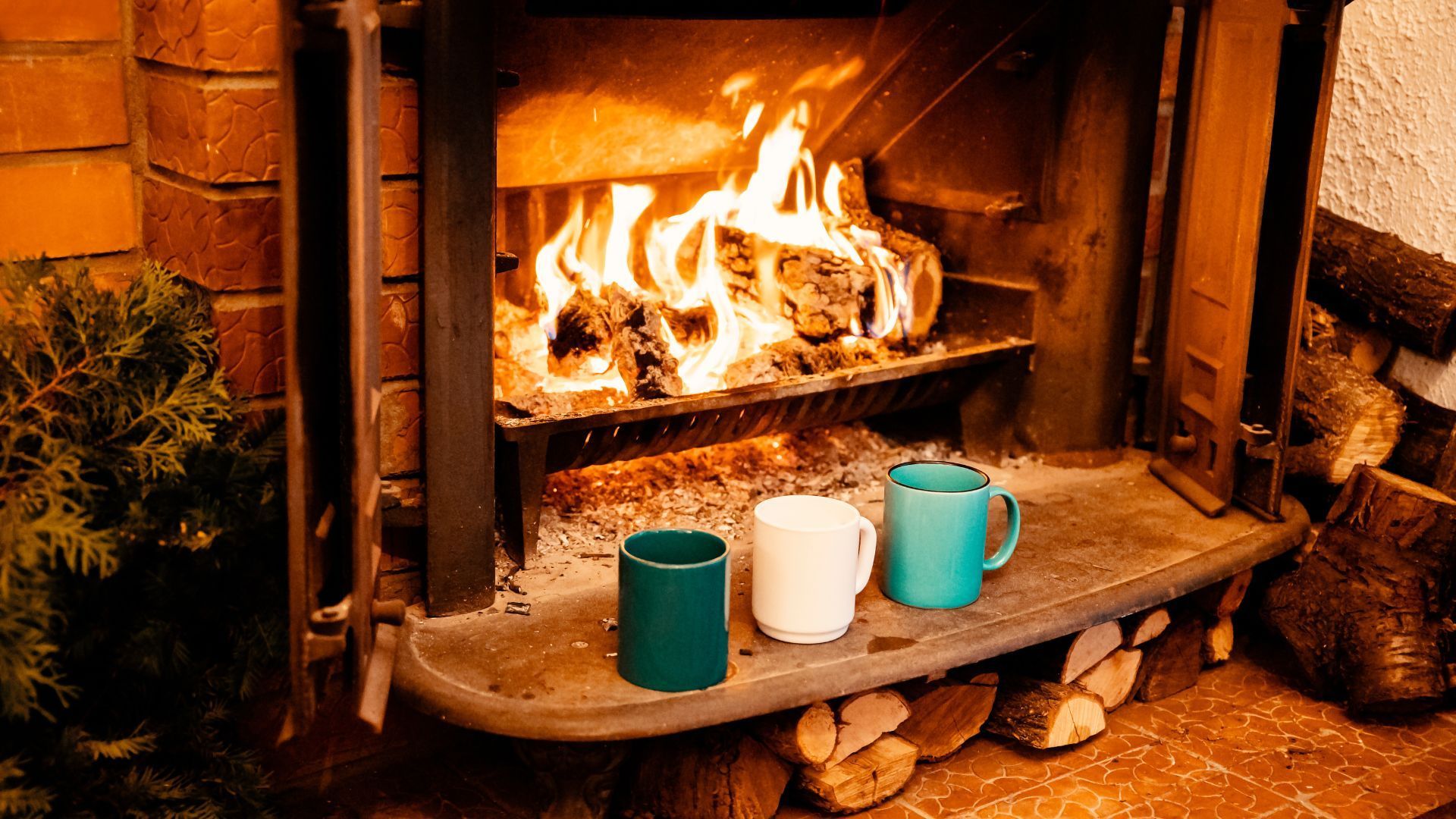 Three coffee cups are sitting in front of a fireplace