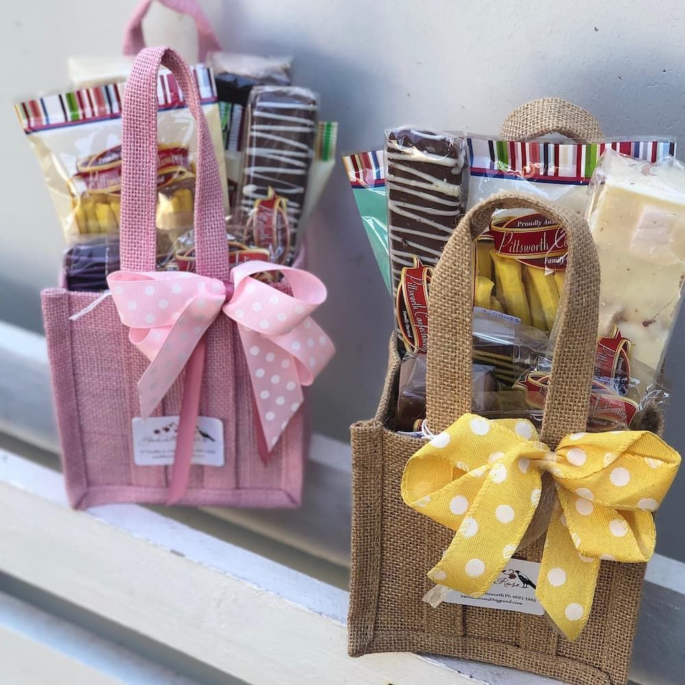 A Pink And A Brown Bag Filled With Candy Are Sitting On A Table — Clover Country Flowers and Gifts In Pittsworth, QLD