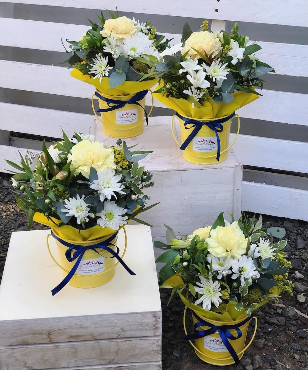 Four Yellow Buckets Filled With Flowers Are Sitting On A Wooden Box — Clover Country Flowers and Gifts In Pittsworth, QLD