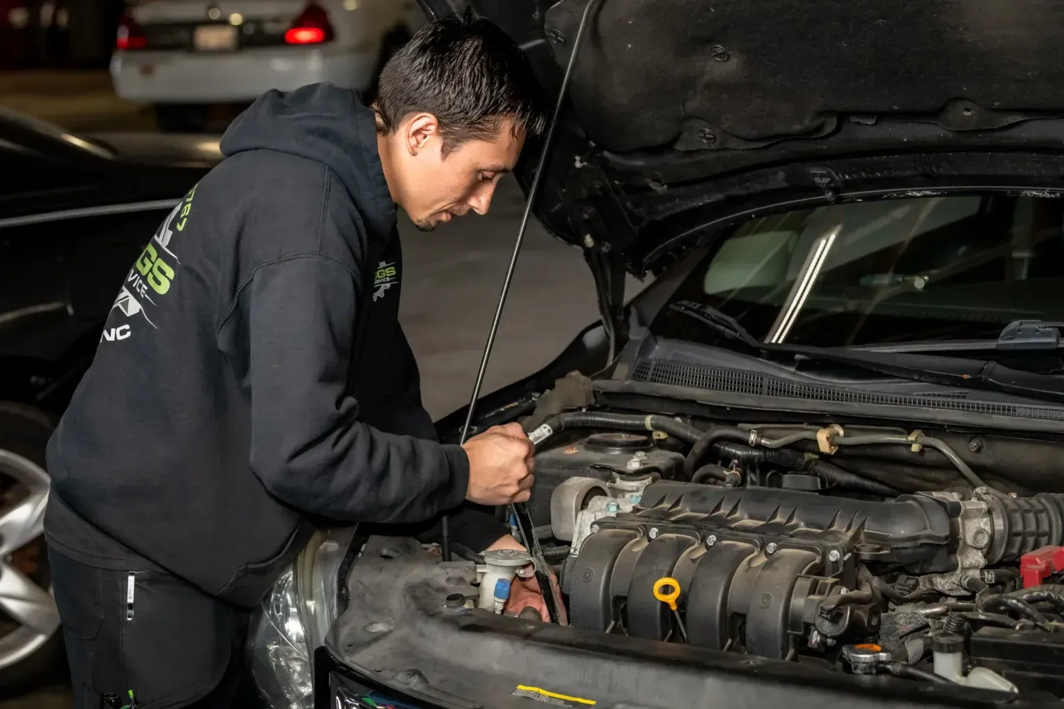 A man is working on the engine of a car.