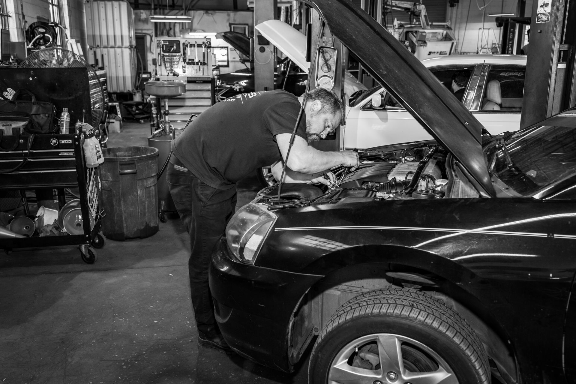 A man is working on a machine in a black and white photo.