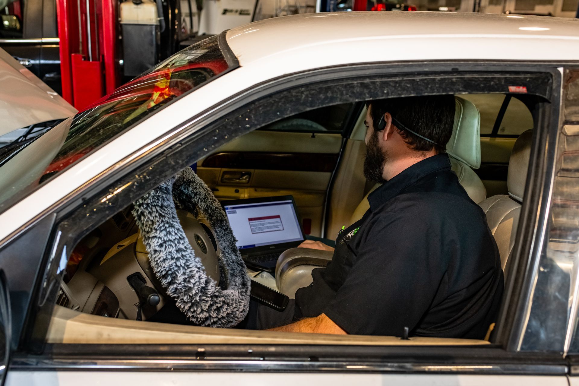 A woman is standing next to a car in a parking lot.