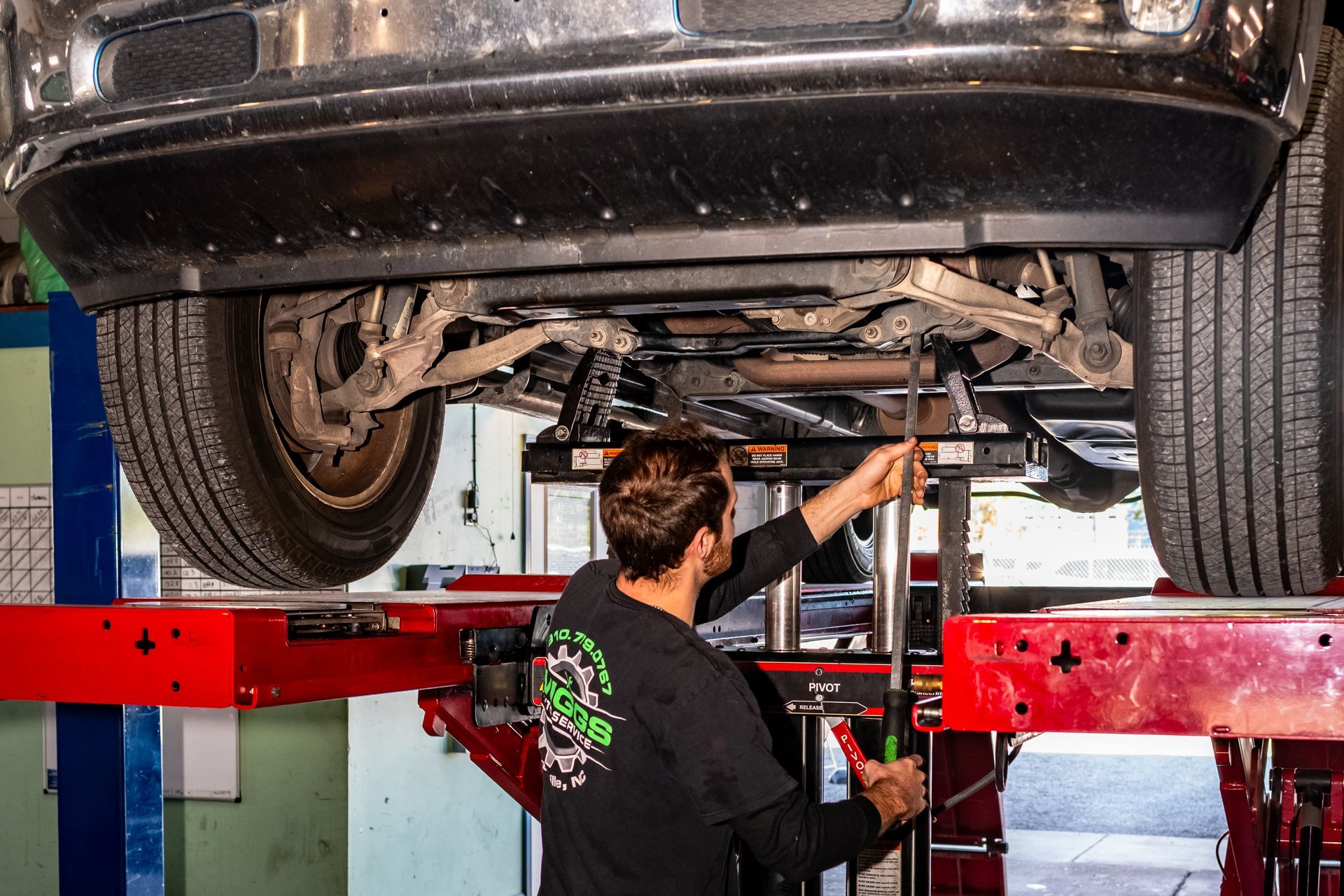 A man is standing in a garage next to a truck.