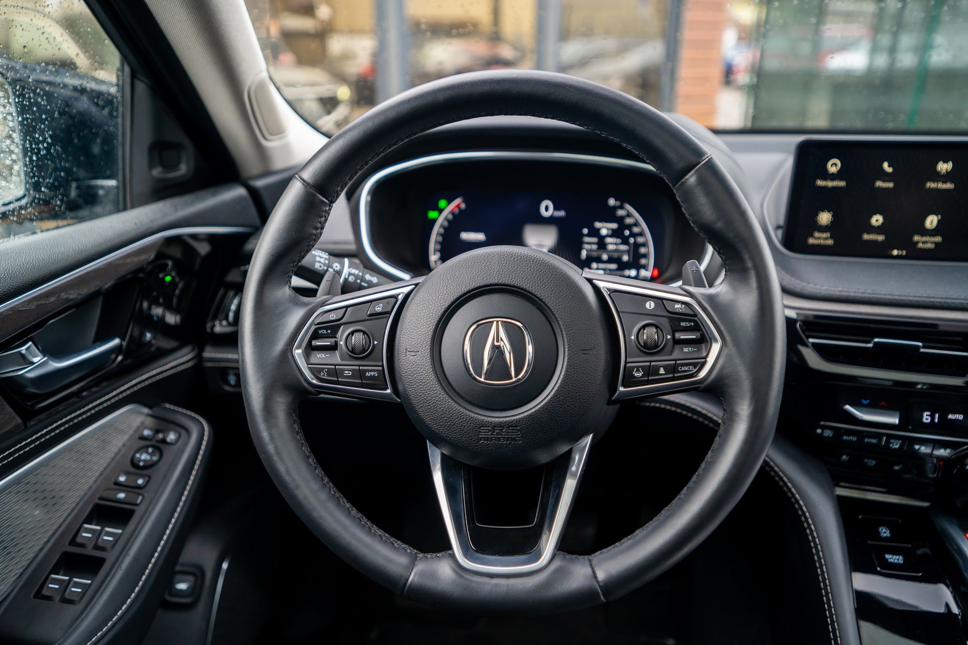 Acura car interior with steering wheel, digital dashboard, and center touchscreen view