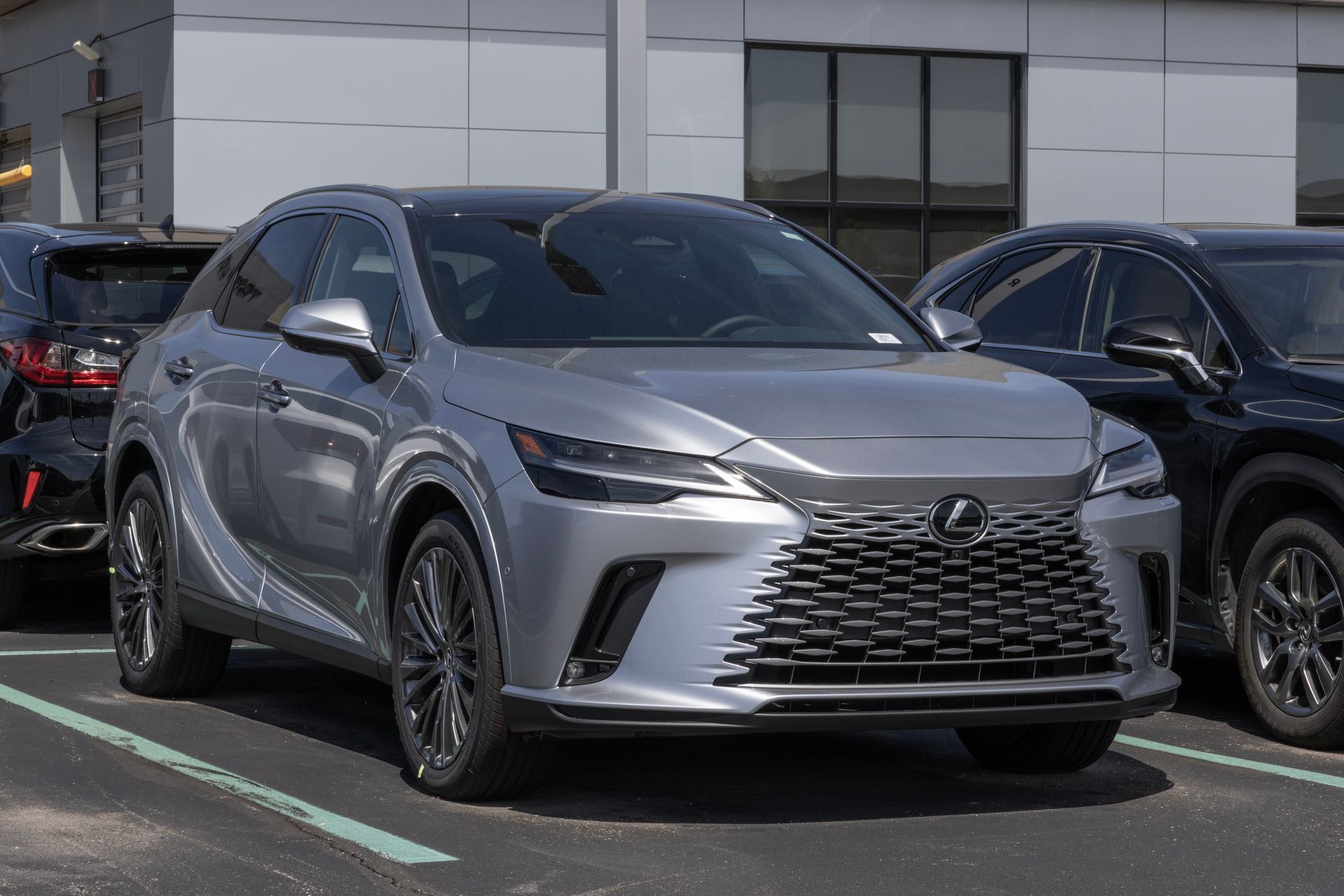 Silver Lexus sedan parked outdoors in front of a dealership, front view