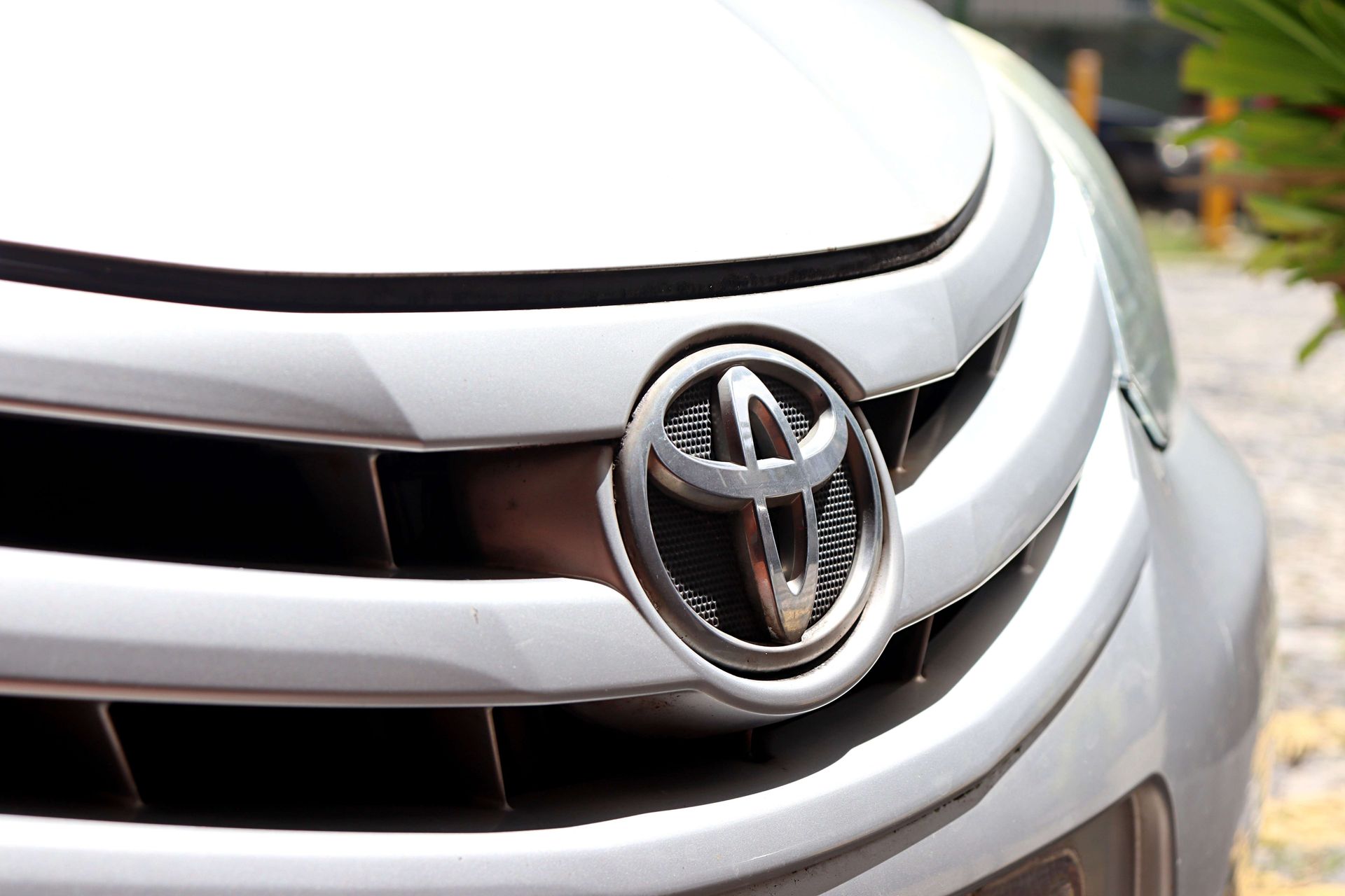 Close-up of a silver Toyota front grille and emblem