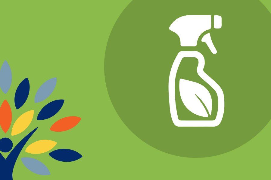 A spray bottle with a green leaf on it is on a green background.
