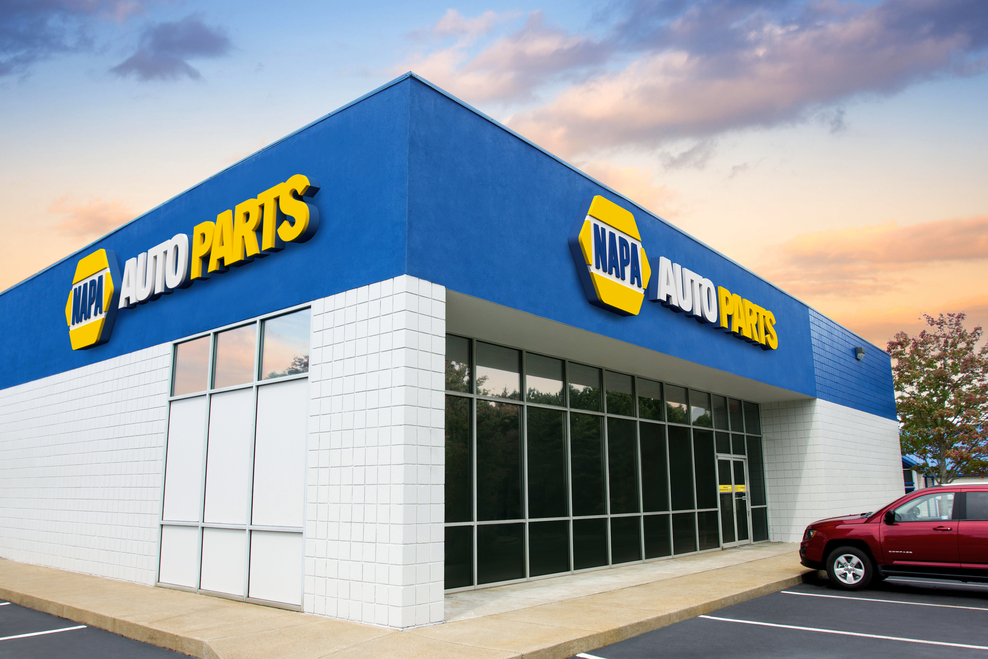 A napa auto parts store with a red truck parked in front of it