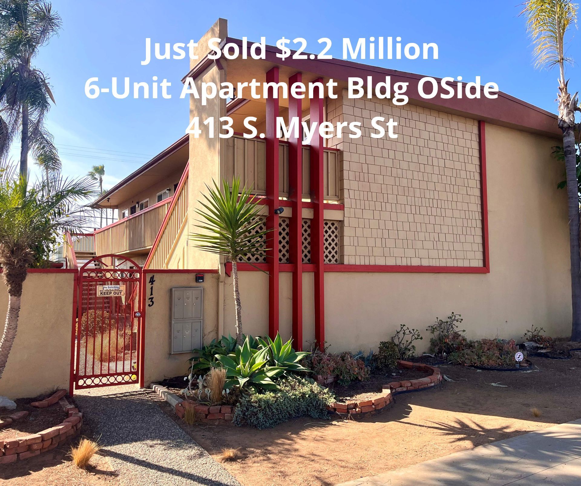 6-unit apartment building exterior with red trim, gated entry, and sign reading “Just Sold $2.2 Million”