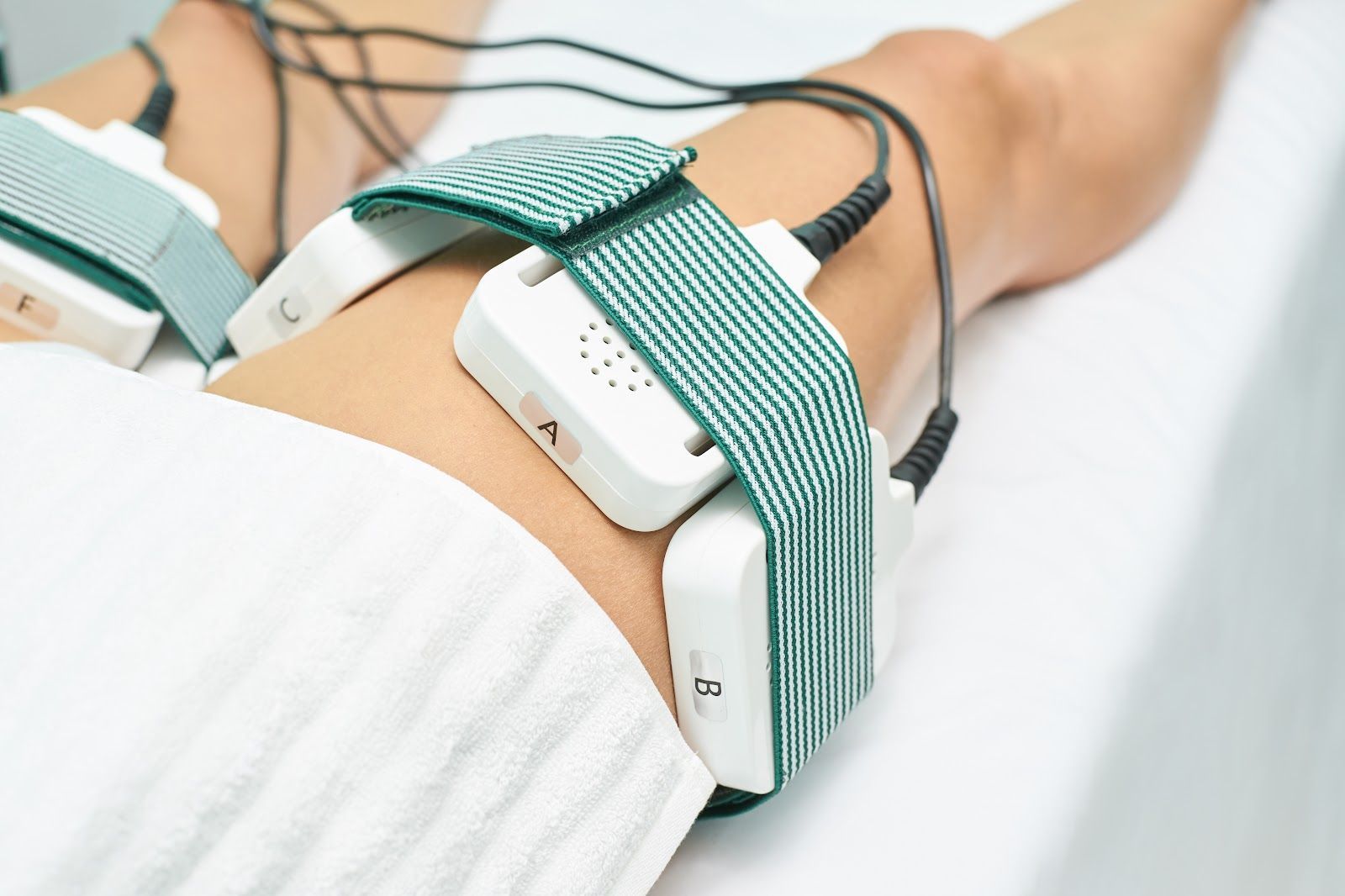 Medical sensors strapped to a patient’s arm with green elastic bands