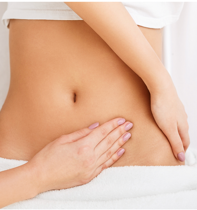 A woman is laying down with her hands on her stomach.