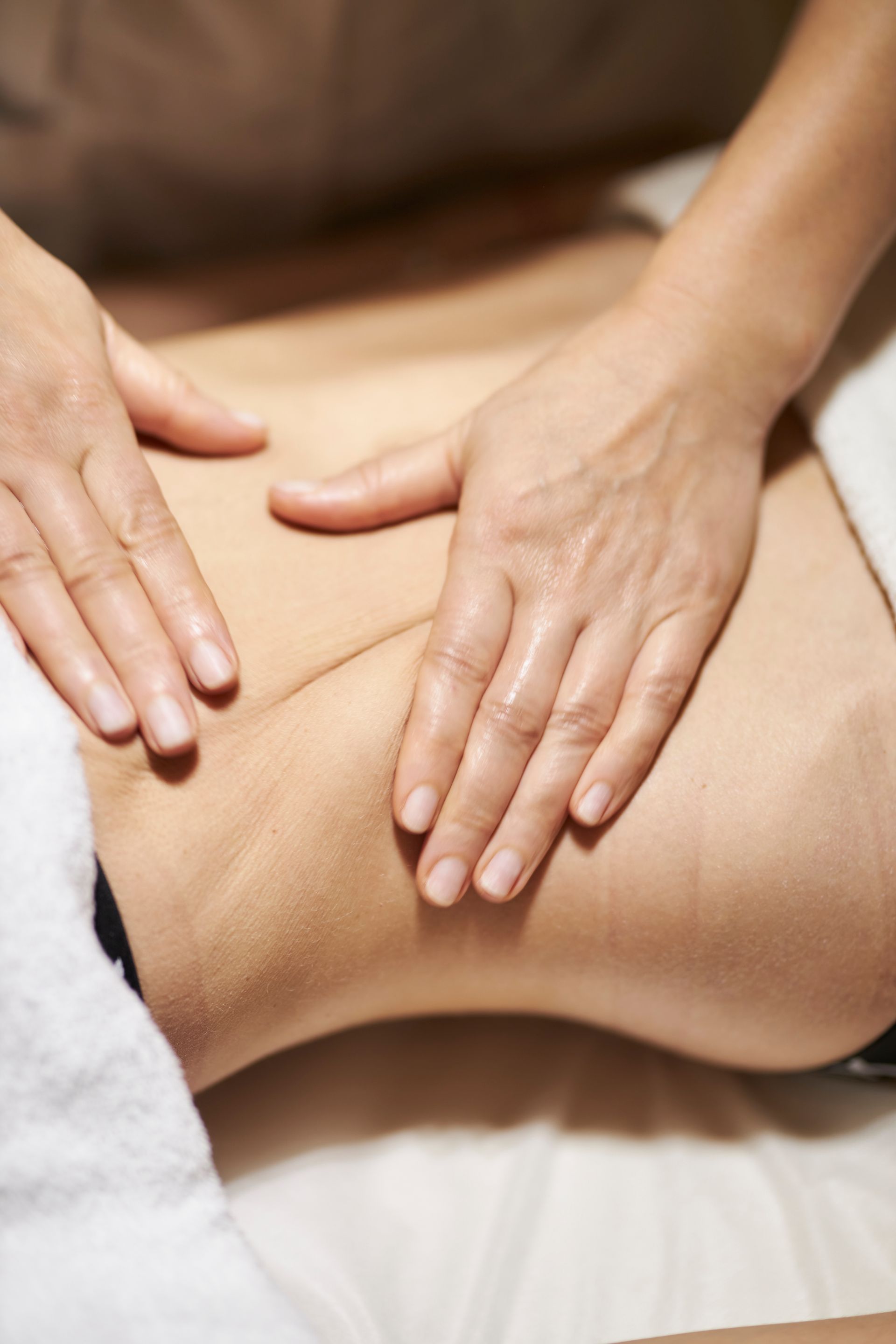 A woman is getting a massage on her back at a spa.